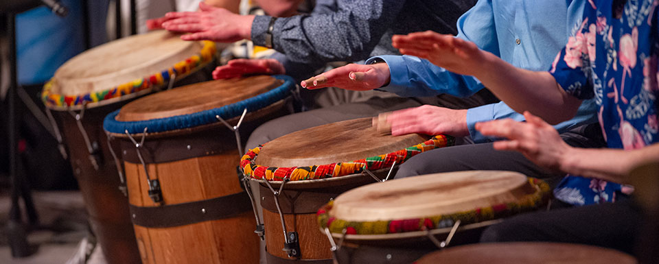 A group of adults play bongo drums during a community music course at UWM.