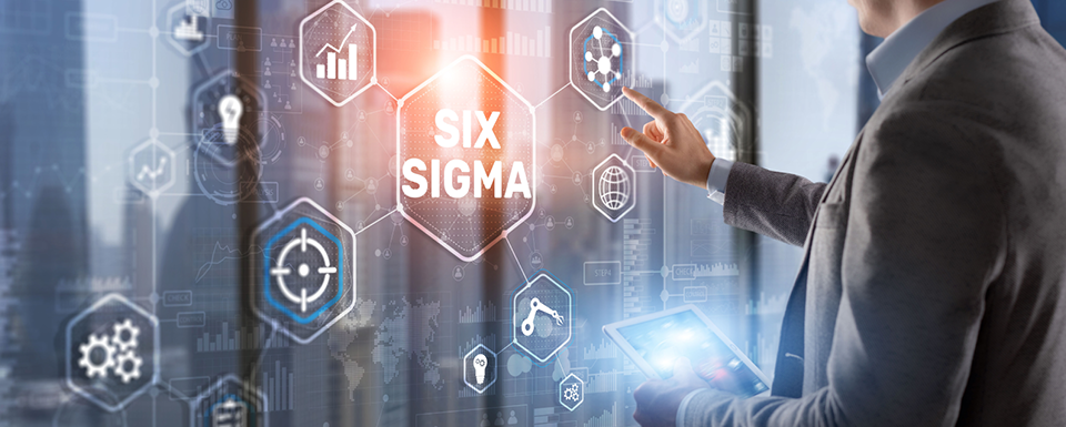 An individual is pointing to a six-sigma schematic projected on a wall from his iPad.
